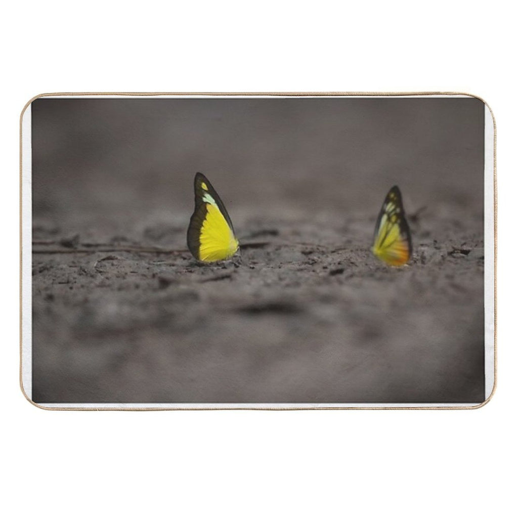 This Image Captures A Brightly Colored Butterfly Settled on Rugged Terrain, Offering A Striking Contrast Between Fragility And R  Versatile Bath Mat